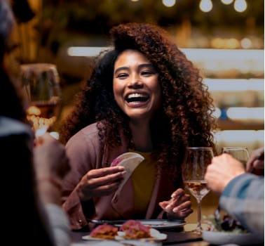 Woman laughing with friends at a restaurant