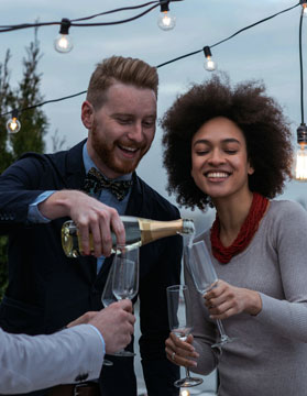 Man Pouring woman Champagne while smiling